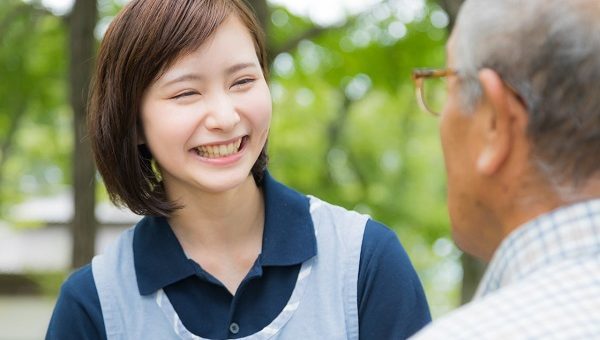 笑顔で高齢の男性に接する女性