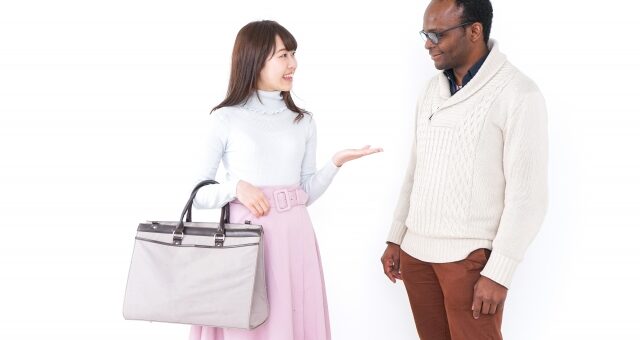 アフリカ系の男性と会話する日本人女性